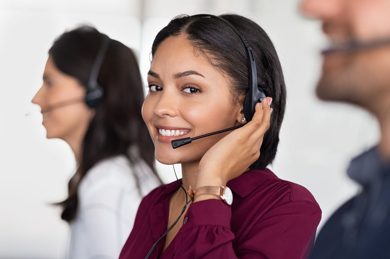 Woman wearing a headset with colleagues in the background