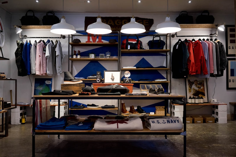 Clothing store interior with shelves displaying various items and clothing.