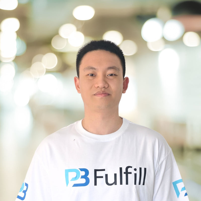 Person wearing a white shirt with 'PB Fulfill' logo against a blurred background