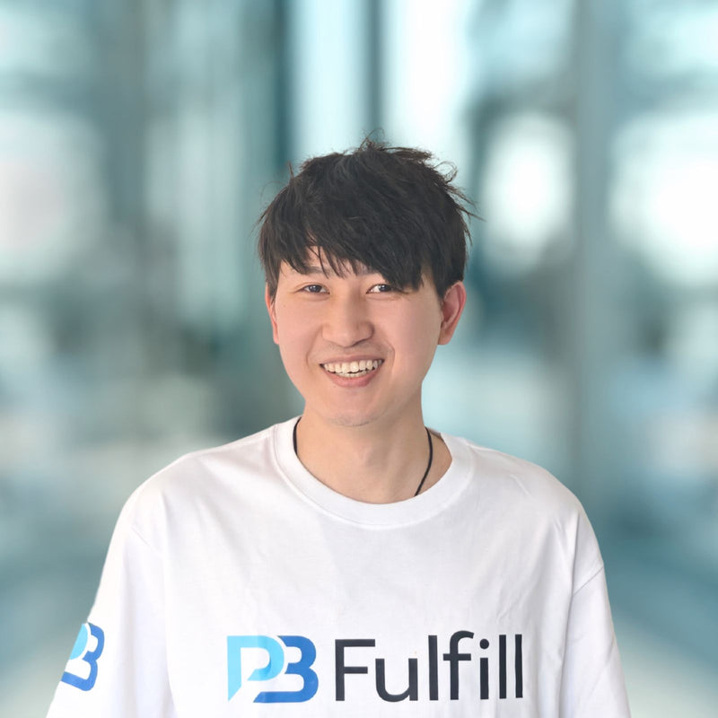 Person wearing a white shirt with 'PB Fulfill' logo against a blurred background