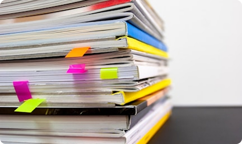 Stack of colorful books or notebooks with flags on a white background
